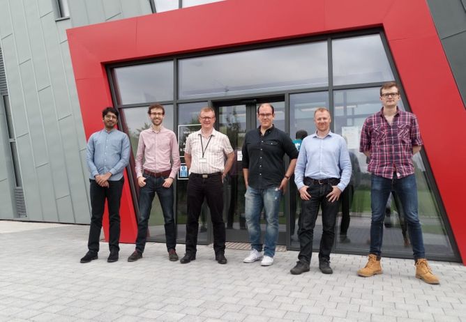The Cheesecake Energy team poses in front of an office building