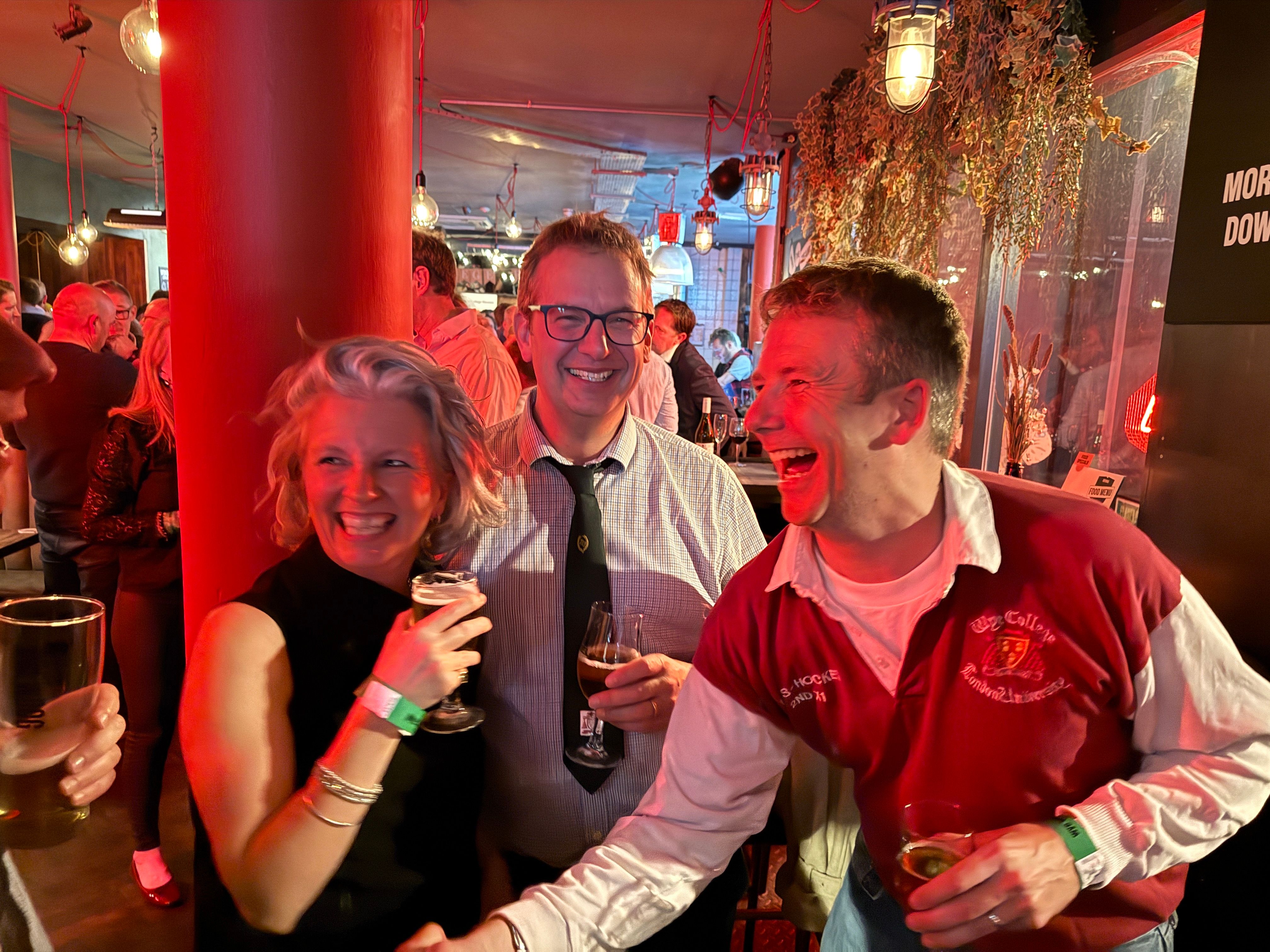 Three Wye alumni pictured laughing at a restaurant or bar at their reunion hosted in central London