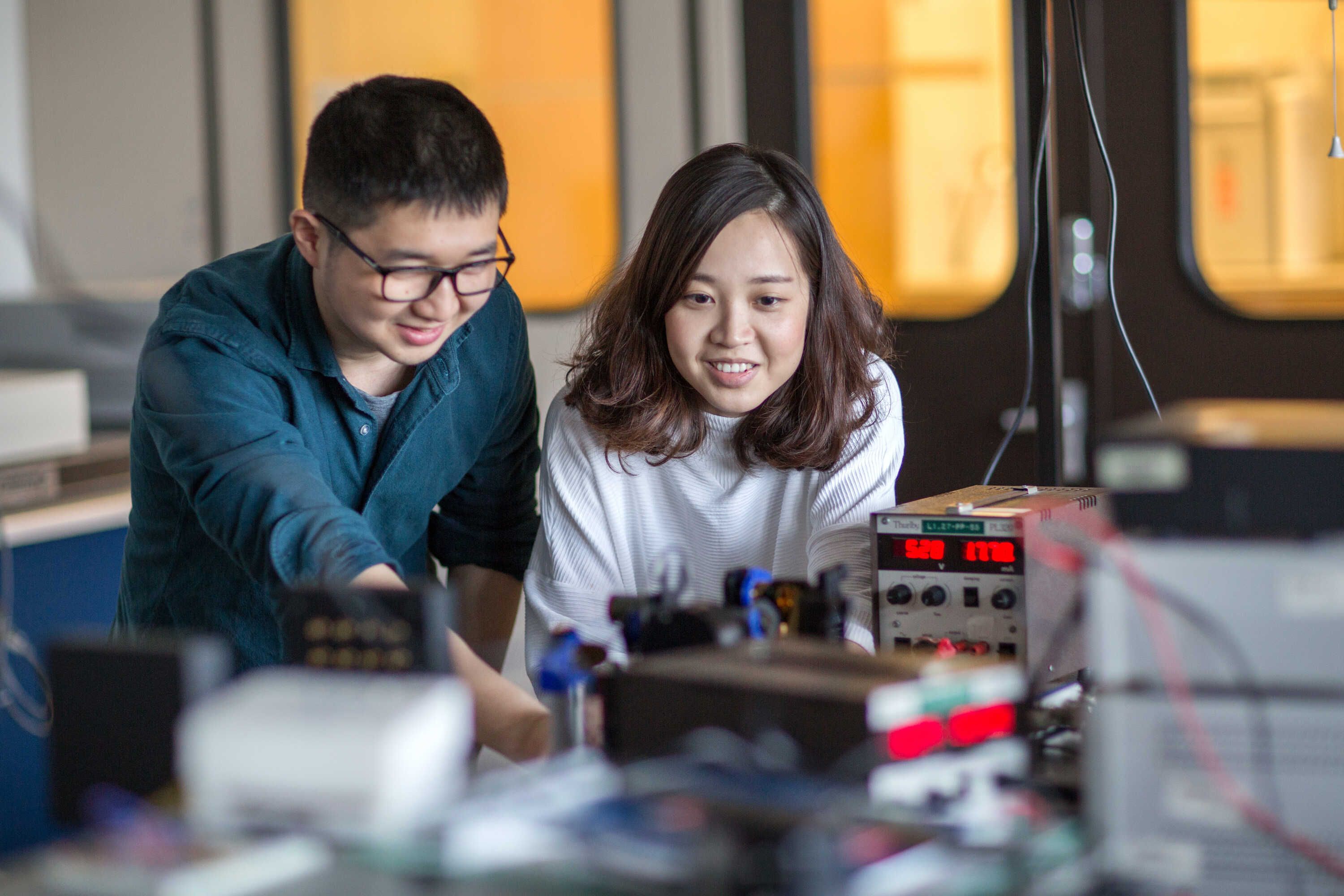 a male and female student viewing their electrical engineering work